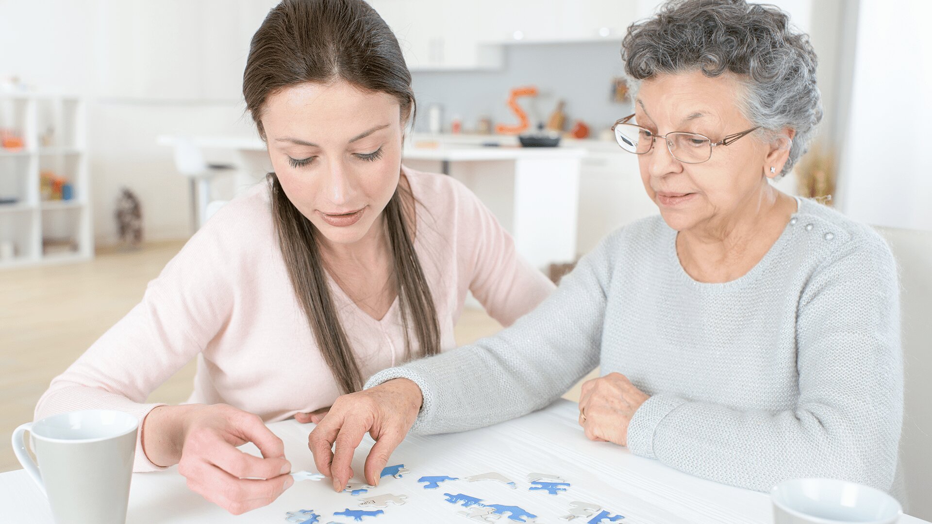 A young woman and senior woman working on a puzzle