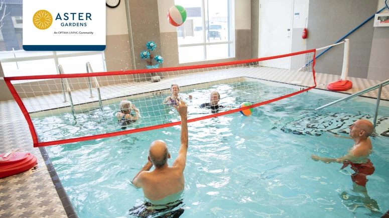 A group of seniors playing water volleyball in an indoor swimming pool