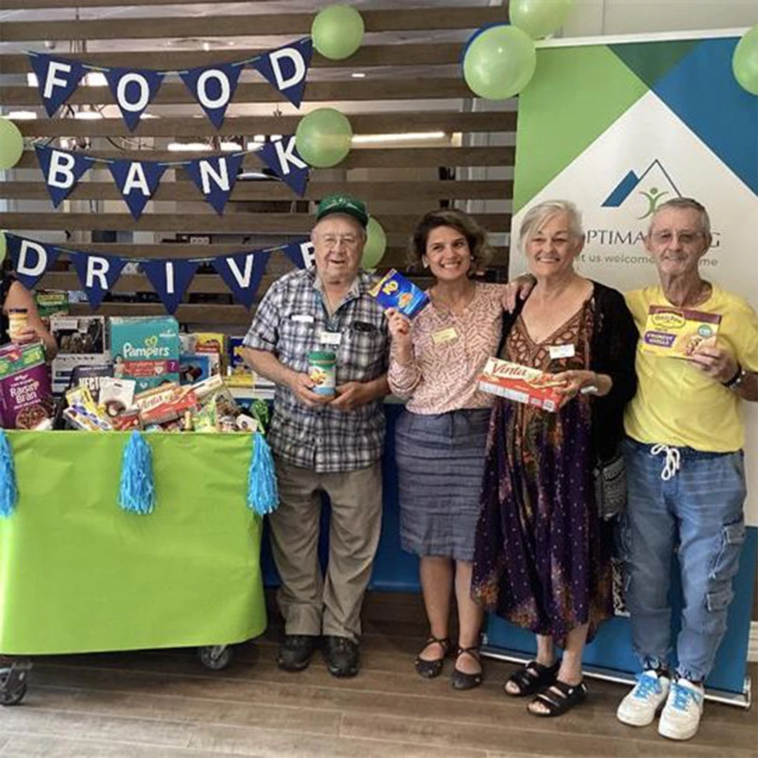 Seniors standing in front of food bank donations