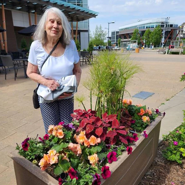 Senior standing next to a planter