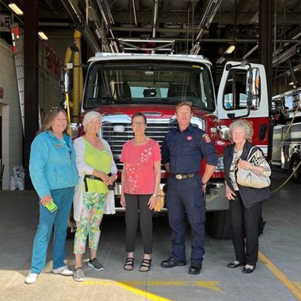 Fireman with some seniors standing in front of a firetruck.