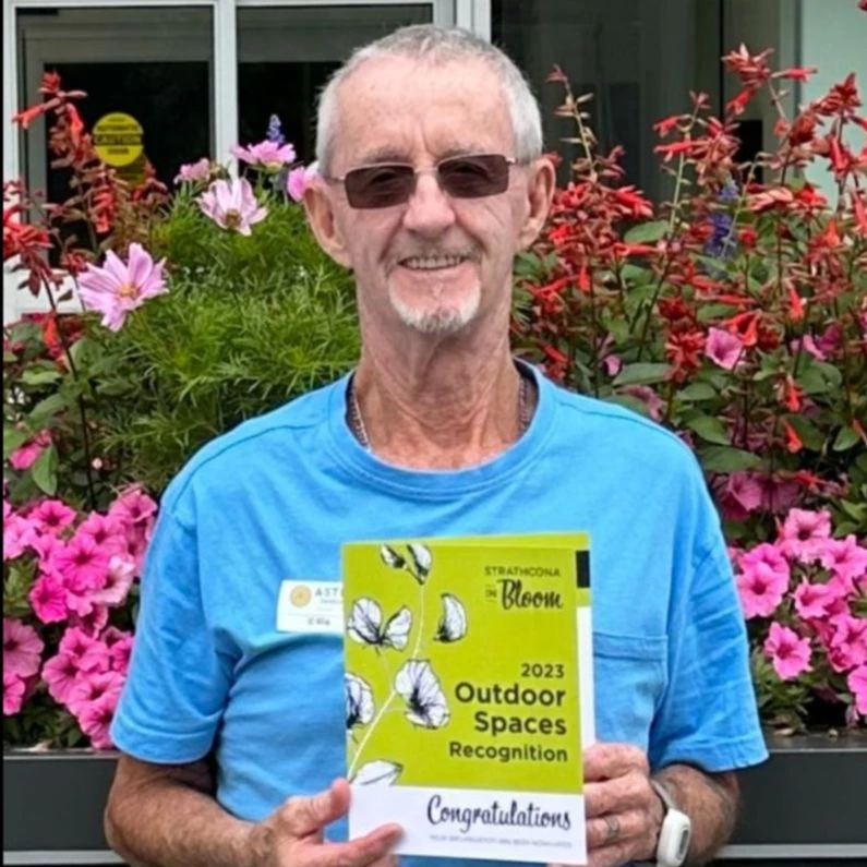 Senior standing with a 2023 Outdoor Spaces Recognition