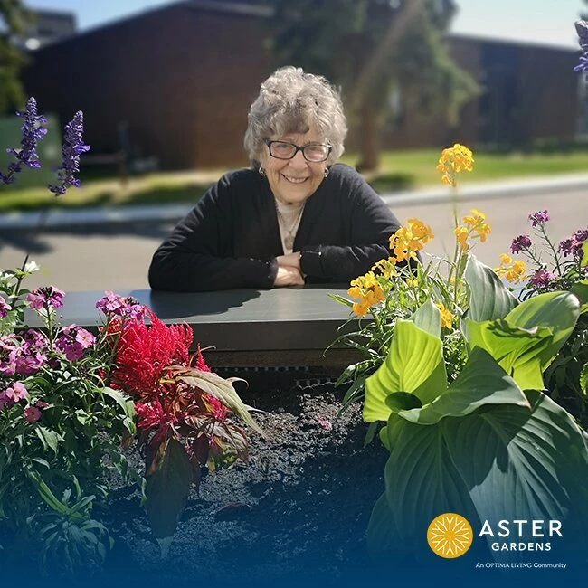 A picture of elderly lady smiling with colourful flowers