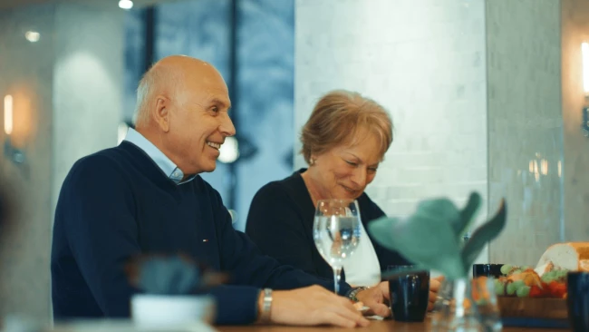 A senior couple laughing and drinking coffee