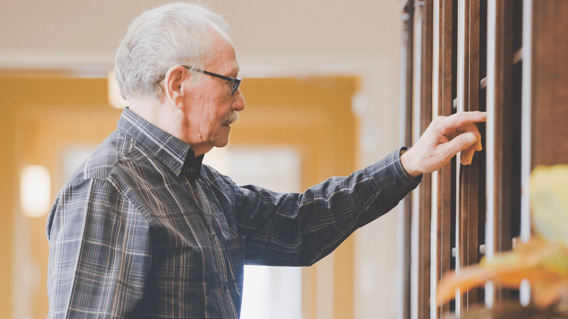 A senior man browsing books in a library