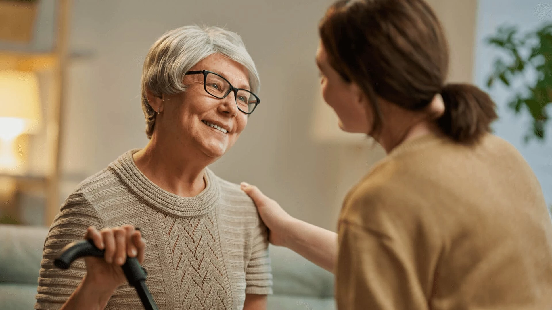 A young woman comforting a senior woman in elderly care