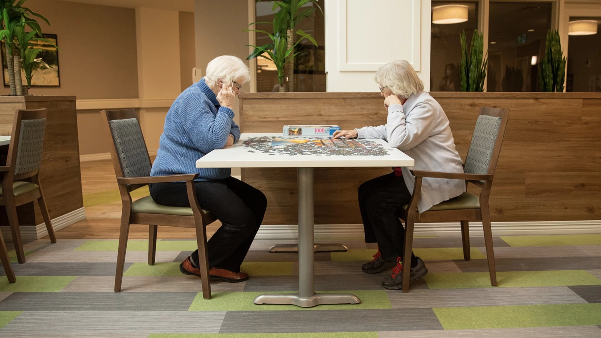 Two elder women's playing game at Aster Garden's common area