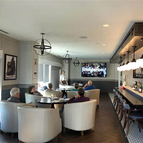 A gathering of senior citizens in the dining area watching TV